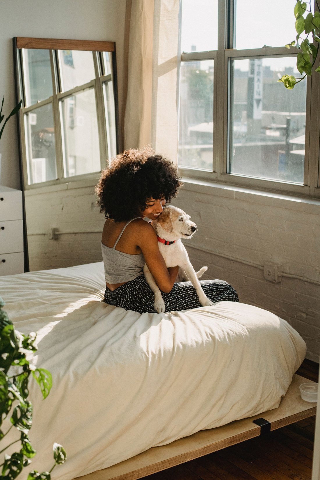 Woman hugging her dog in a bright, comfortable home